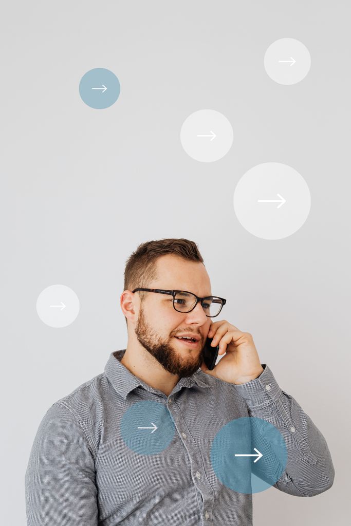 Young man standing indoors engaged in a phone call, surrounded by digital arrow overlays.